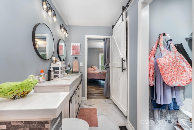 ensuite bathroom with vanity and marble look tile flooring