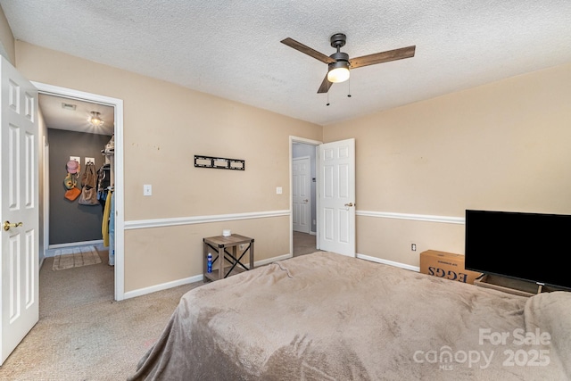 carpeted bedroom with baseboards, a ceiling fan, and a textured ceiling