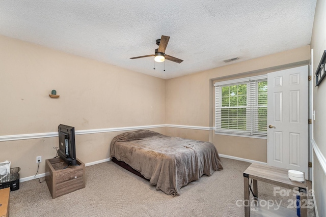 carpeted bedroom featuring baseboards, a textured ceiling, and ceiling fan
