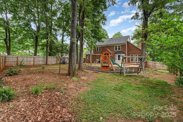 fenced backyard with a playground