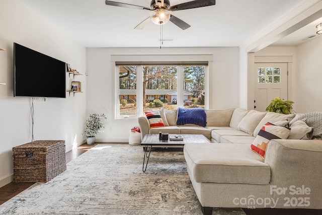 living room featuring dark wood-type flooring and ceiling fan