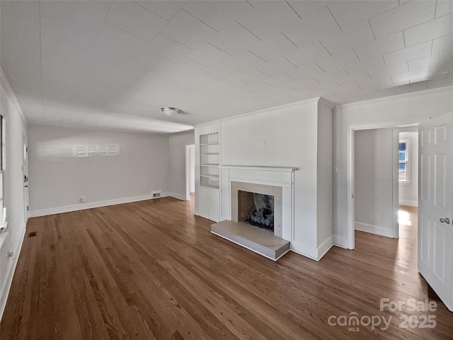 unfurnished living room with dark hardwood / wood-style flooring and built in features