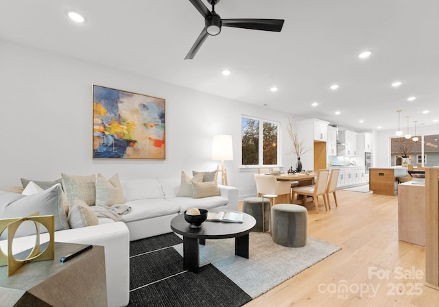 living room featuring ceiling fan and light wood-type flooring