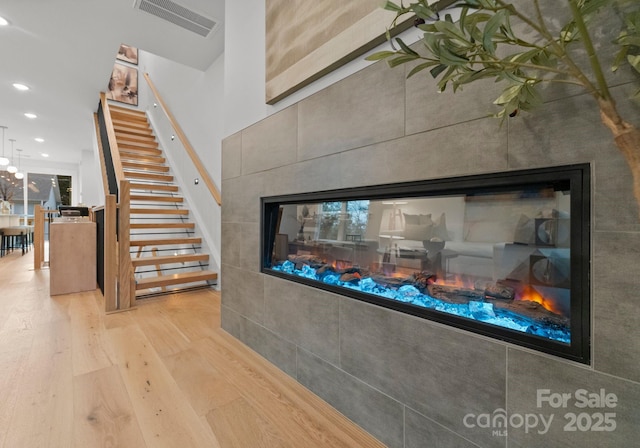 details featuring hardwood / wood-style floors and a tile fireplace