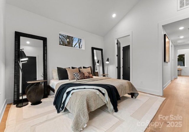 bedroom with lofted ceiling and light hardwood / wood-style flooring