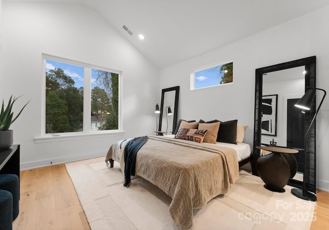 bedroom with high vaulted ceiling and light hardwood / wood-style flooring