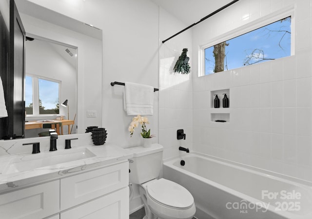 full bathroom with tiled shower / bath, a healthy amount of sunlight, vanity, and toilet