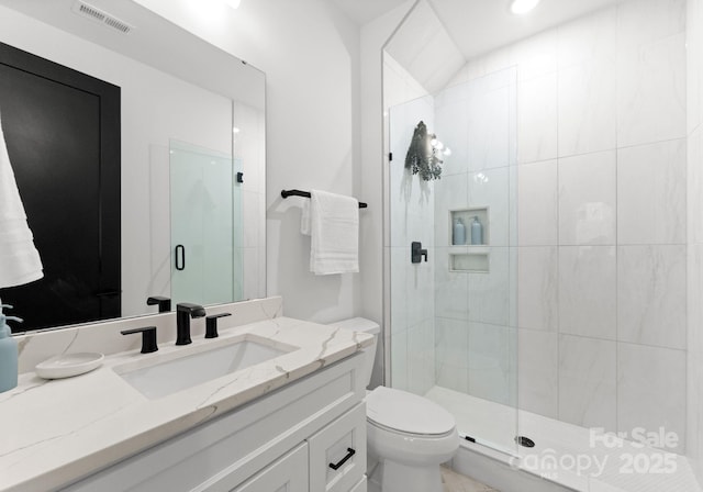 bathroom with vanity, toilet, and a shower with shower door