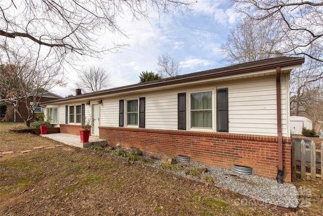 view of front of home with a patio area and brick siding