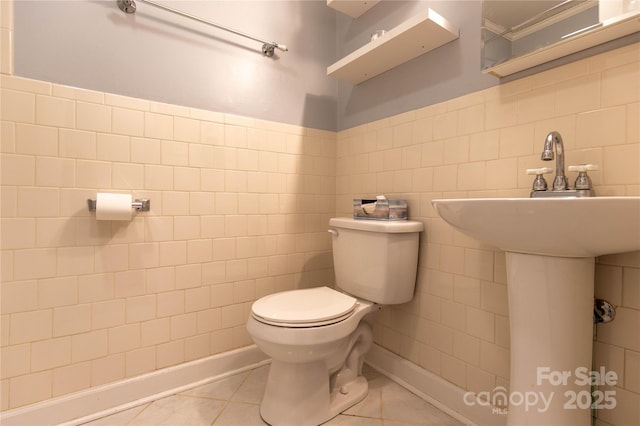 half bathroom featuring tile patterned floors, toilet, and tile walls