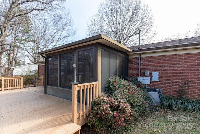 view of property exterior with a wooden deck and a sunroom