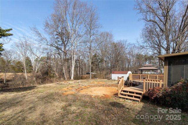 view of yard with a gazebo, a storage unit, a deck, and an outdoor structure