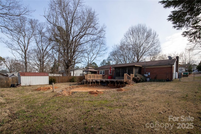 view of yard with a shed, a sunroom, and a deck