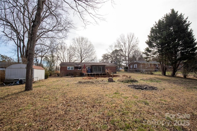 view of front of house featuring an outbuilding and fence