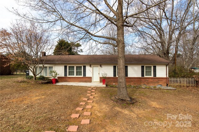 single story home with fence, brick siding, and a chimney