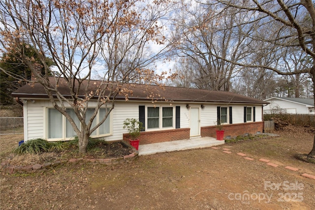 ranch-style house featuring brick siding and fence