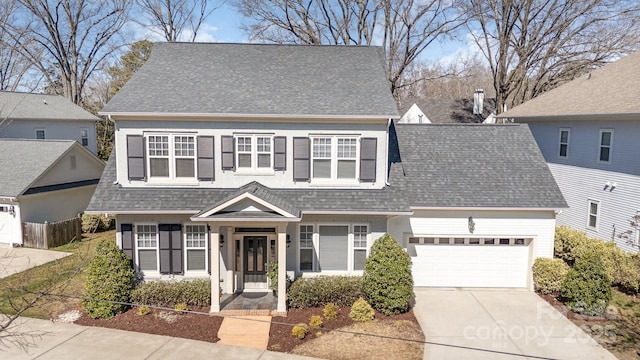 view of front of property with a shingled roof, driveway, and a garage