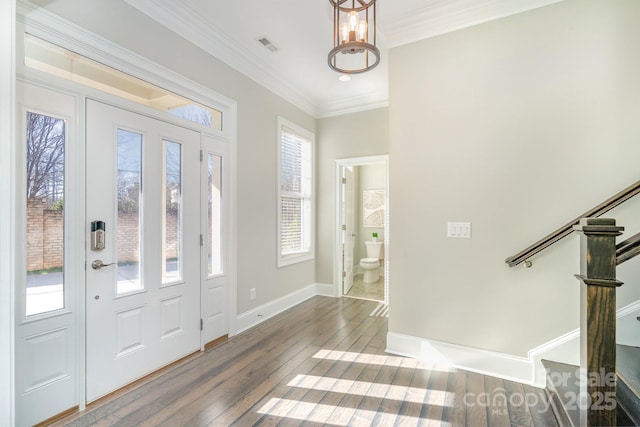 foyer entrance featuring a chandelier, baseboards, ornamental molding, stairway, and wood-type flooring