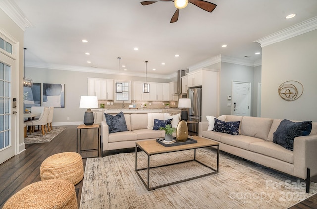 living room with recessed lighting, wood finished floors, a ceiling fan, baseboards, and ornamental molding