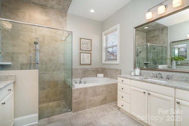 bathroom featuring a stall shower, tile patterned floors, a garden tub, and vanity