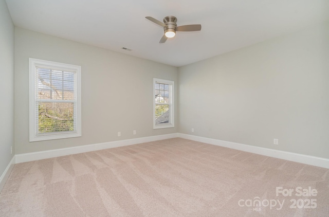 spare room featuring a ceiling fan, baseboards, visible vents, and carpet flooring