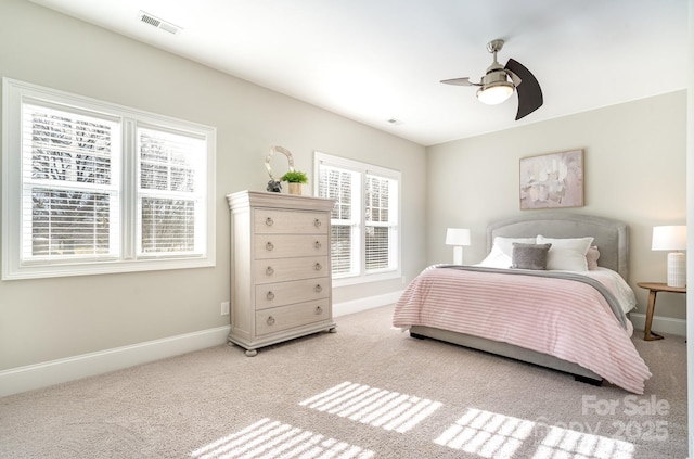 carpeted bedroom with visible vents, ceiling fan, and baseboards