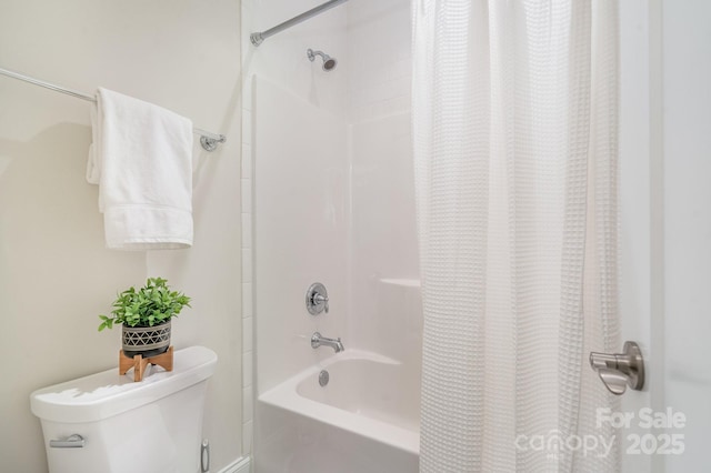 bathroom featuring toilet and shower / bath combination with curtain