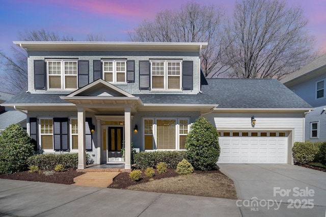 view of front of property featuring a garage, driveway, and a shingled roof