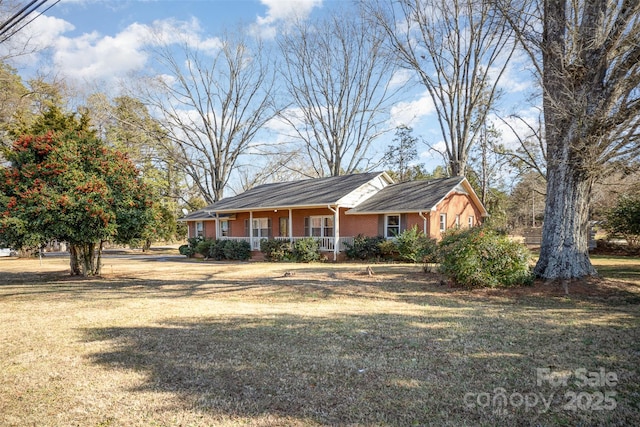 ranch-style home featuring a front yard and covered porch