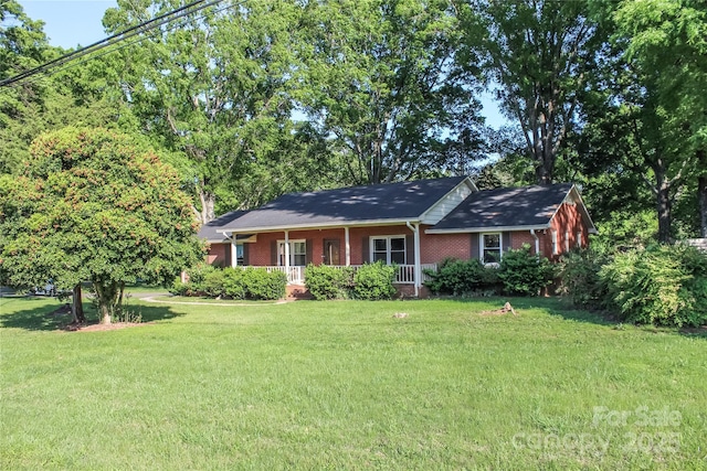 single story home with a porch, a front yard, and brick siding