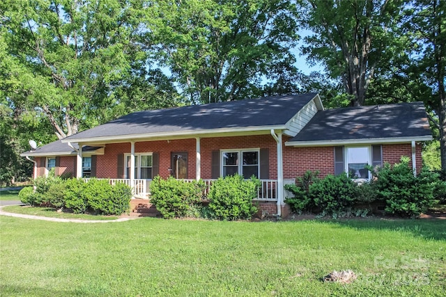 single story home with a front yard, a porch, and brick siding