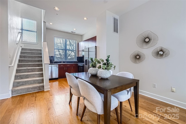 dining space featuring sink and light hardwood / wood-style flooring