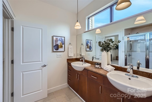 bathroom with an enclosed shower, vanity, and tile patterned floors