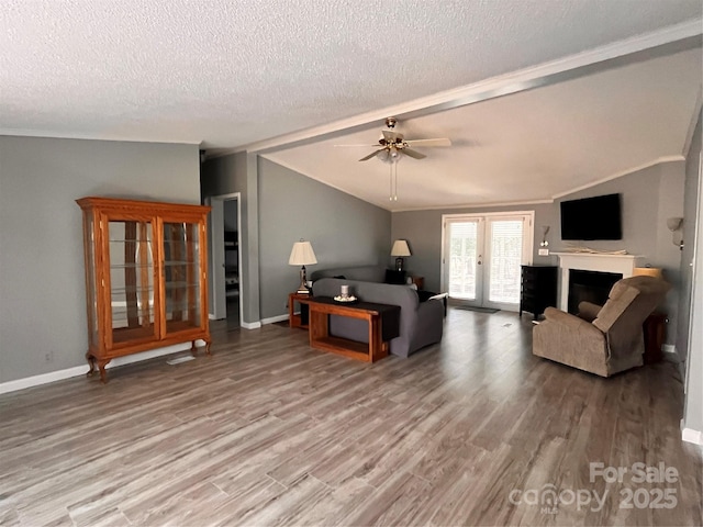 living room featuring lofted ceiling, hardwood / wood-style floors, a textured ceiling, and ceiling fan