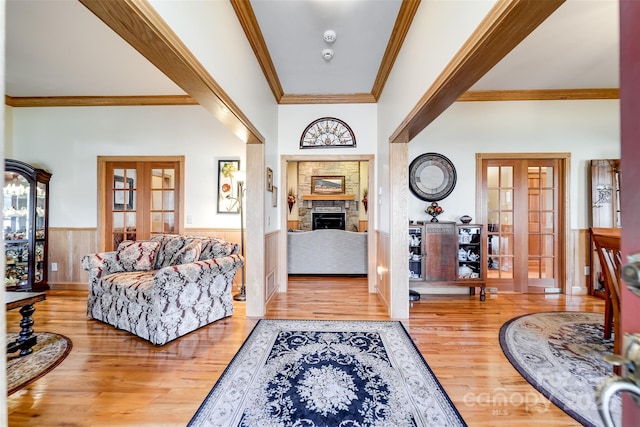 living room featuring crown molding, hardwood / wood-style floors, a fireplace, and french doors