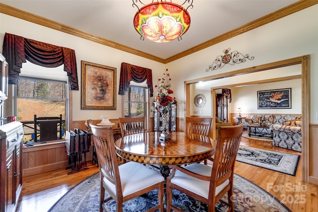 dining area with crown molding and light hardwood / wood-style flooring