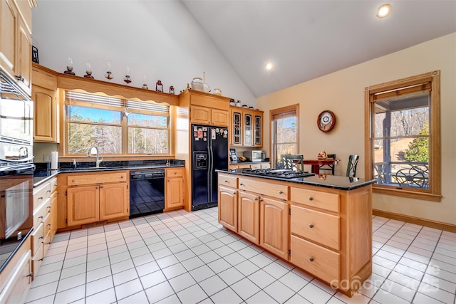 kitchen with sink, a wealth of natural light, black appliances, and a kitchen island