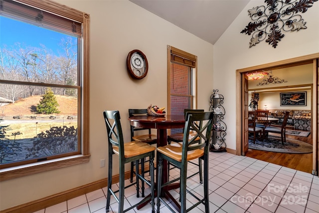 tiled dining room with lofted ceiling