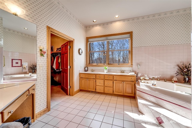 bathroom featuring vanity, tile patterned floors, and tiled bath