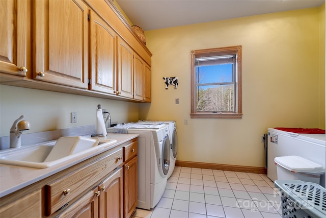 laundry room with sink, washing machine and dryer, cabinets, and light tile patterned flooring