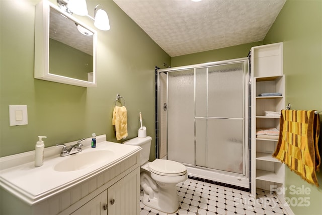 bathroom featuring walk in shower, vanity, toilet, and a textured ceiling