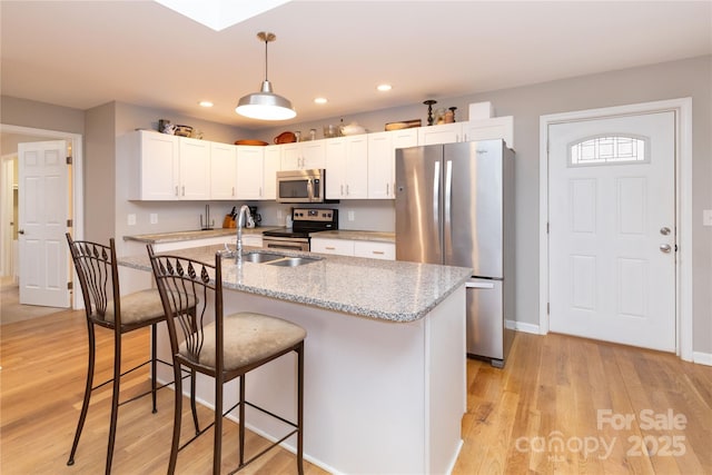 210 State St, Asheville, NC 28806 - kitchen featuring appliances with stainless steel finishes, decorative light fixtures, white cabinetry, sink, and light stone counters