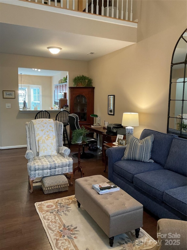 living room with hardwood / wood-style flooring and a towering ceiling