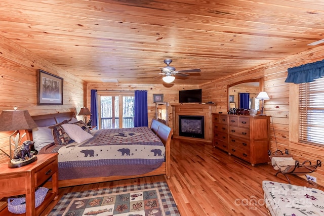 bedroom with wood-type flooring, wooden walls, and wooden ceiling