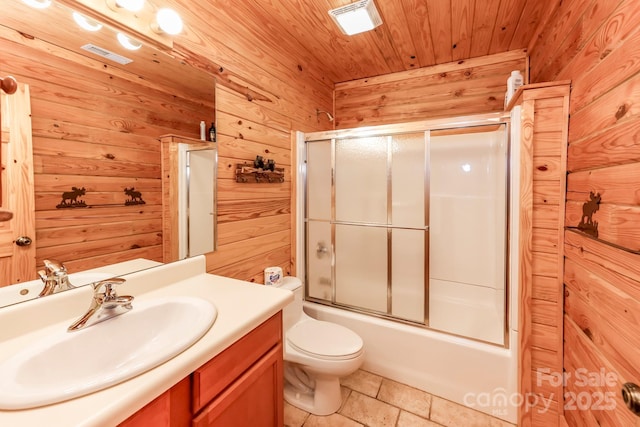 full bathroom featuring toilet, wood ceiling, shower / bath combination with glass door, vanity, and wooden walls