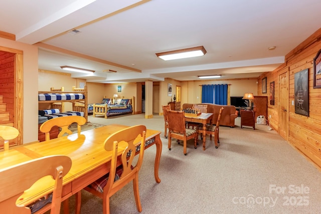 dining space with wooden walls and carpet