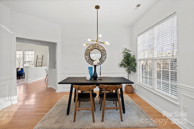 dining room with an inviting chandelier and light wood-type flooring