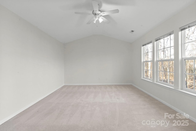 carpeted spare room featuring vaulted ceiling and ceiling fan