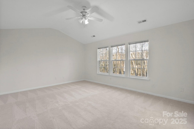 empty room featuring light carpet, lofted ceiling, and ceiling fan