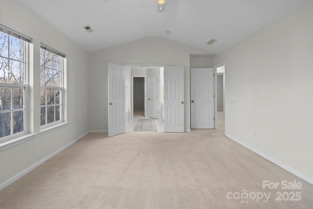 unfurnished bedroom featuring lofted ceiling and light carpet